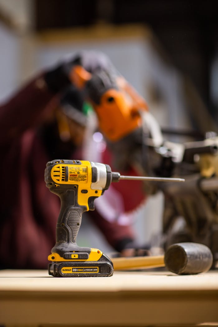 Cordless drill with lithium battery in workshop setting, ideal for carpentry and construction projects.